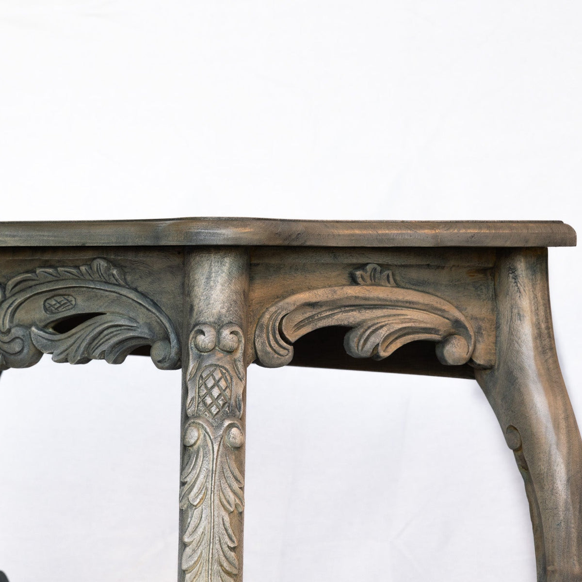 An ornate carved wooden console table with a distressed gray-brown finish, shown against a plain white background.